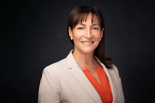 Professional headshot of a woman in a white blazer