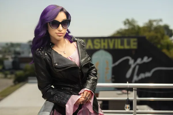 A female singer in front of the Nashville skyline